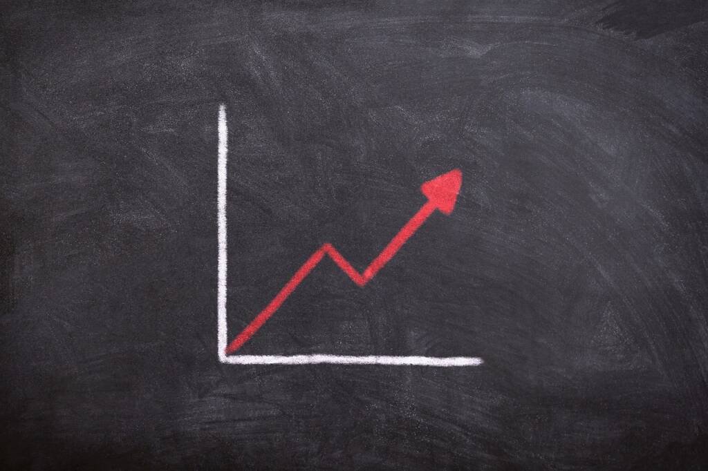 Graphique dessiné à la craie sur un tableau noir avec une flèche qui monte en zigzag, illustrant le vrai coût d’un divorce entre frais visibles et dépenses cachées.